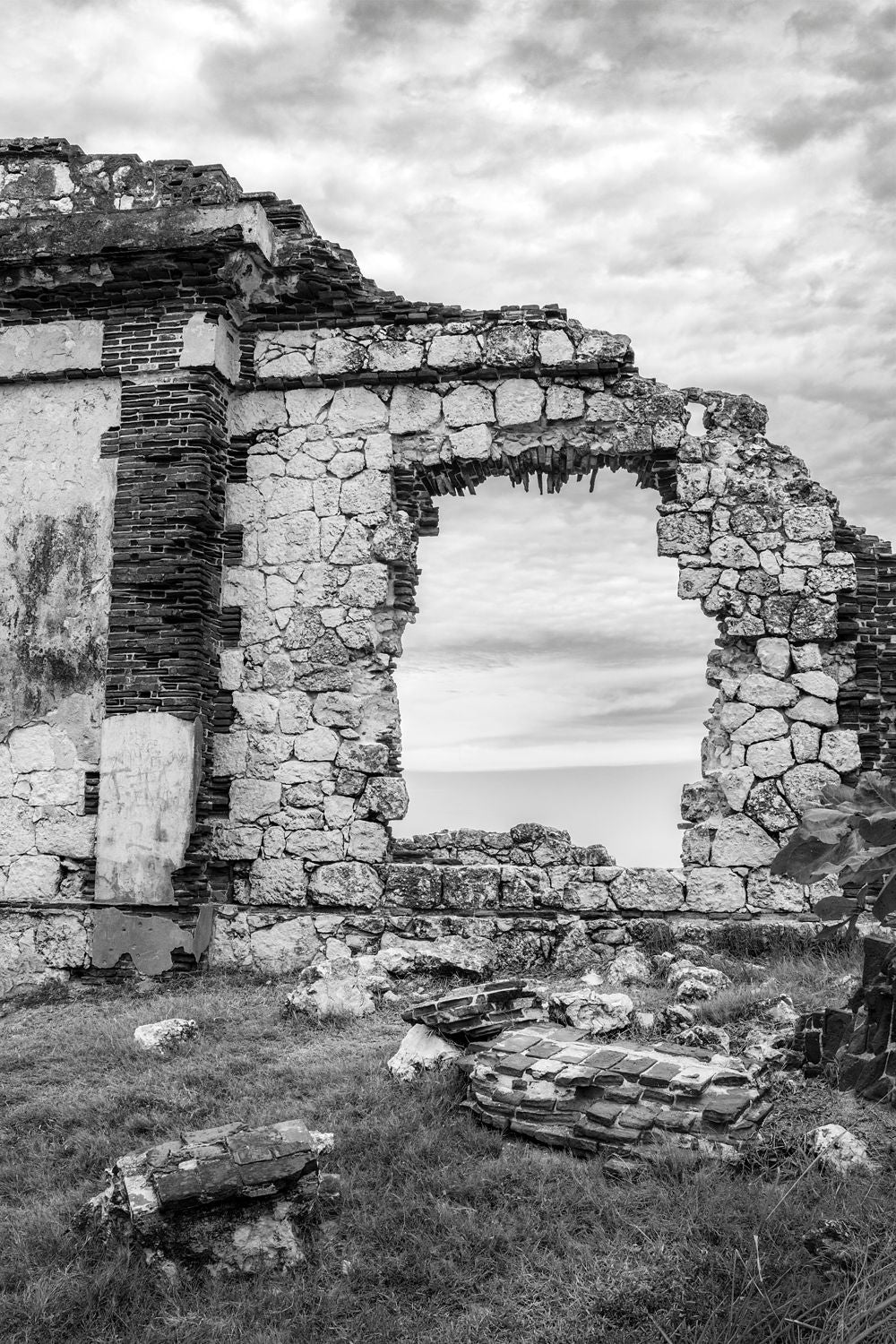 Black-and-white photograph of a stone portal at the Punta Borinquen Lighthouse ruins in Puerto Rico.