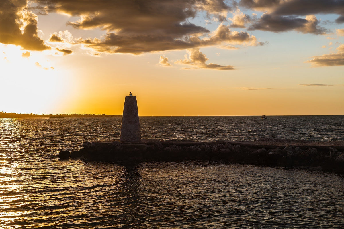 Stone harbor beacon beside the water in warm golden-hour light in the Florida Keys.