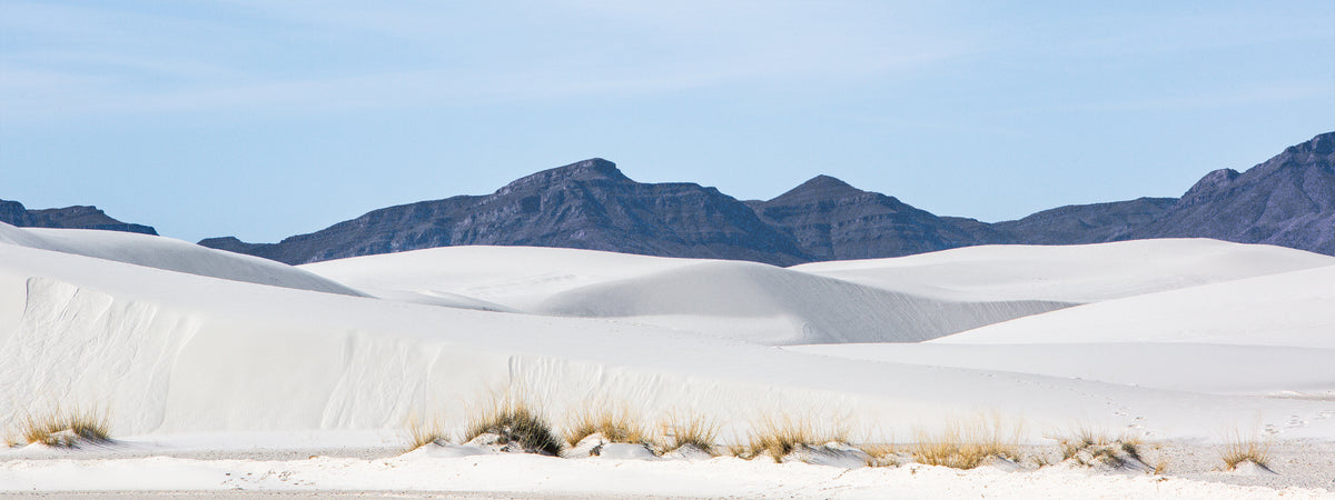 Rolling white gypsum dunes leading toward distant mountains at White Sands National Park, New Mexico