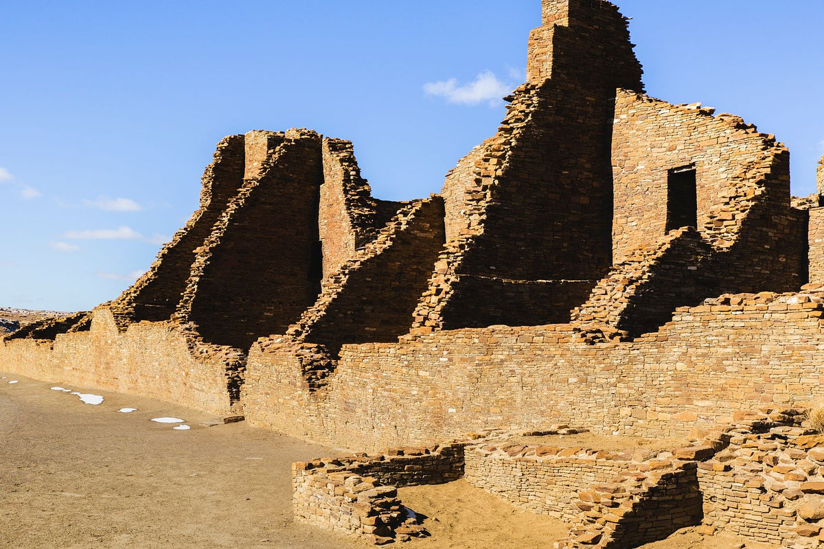 Weathered masonry walls and openings beneath a blue sky at Chaco Canyon, New Mexico.