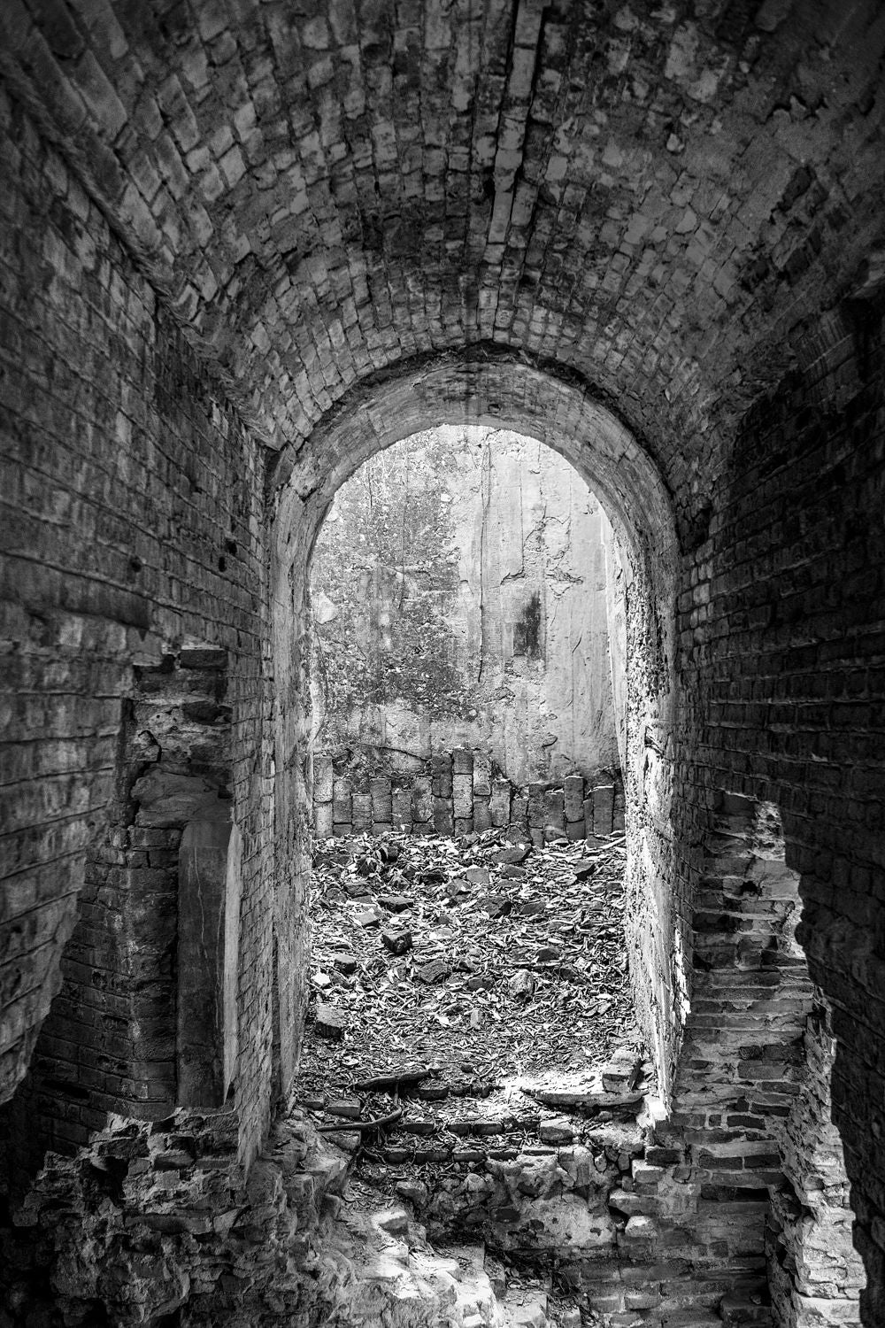 Black-and-white photograph of a brick doorway at the Central Playa Grande sugar mill ruins in Vieques, Puerto Rico.