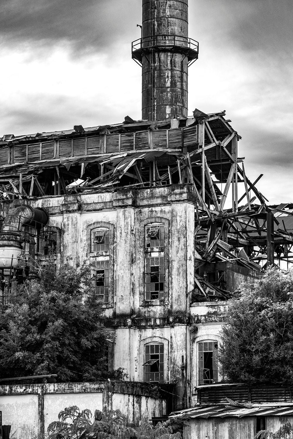 Black-and-white photograph of the Central Coloso tower amid sugar mill ruins in Aguada, Puerto Rico.