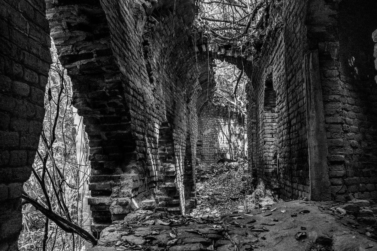 Black-and-white photograph of the interior of the Central Playa Grande sugar mill ruins in Vieques, Puerto Rico.