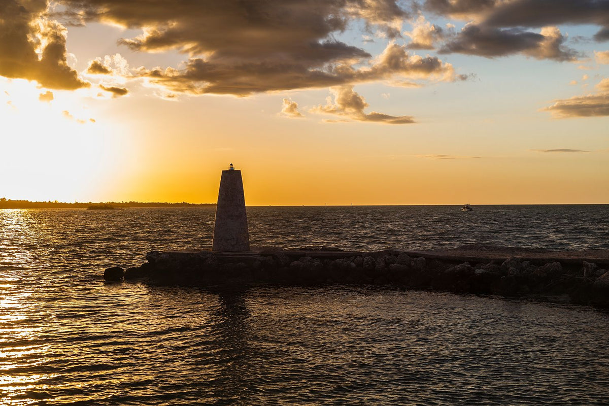 Stone harbor beacon beside the water in warm golden-hour light in the Florida Keys.
